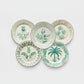 Green Casa Nuno assorted ceramic dinner plates with hand-painted botanical designs.
