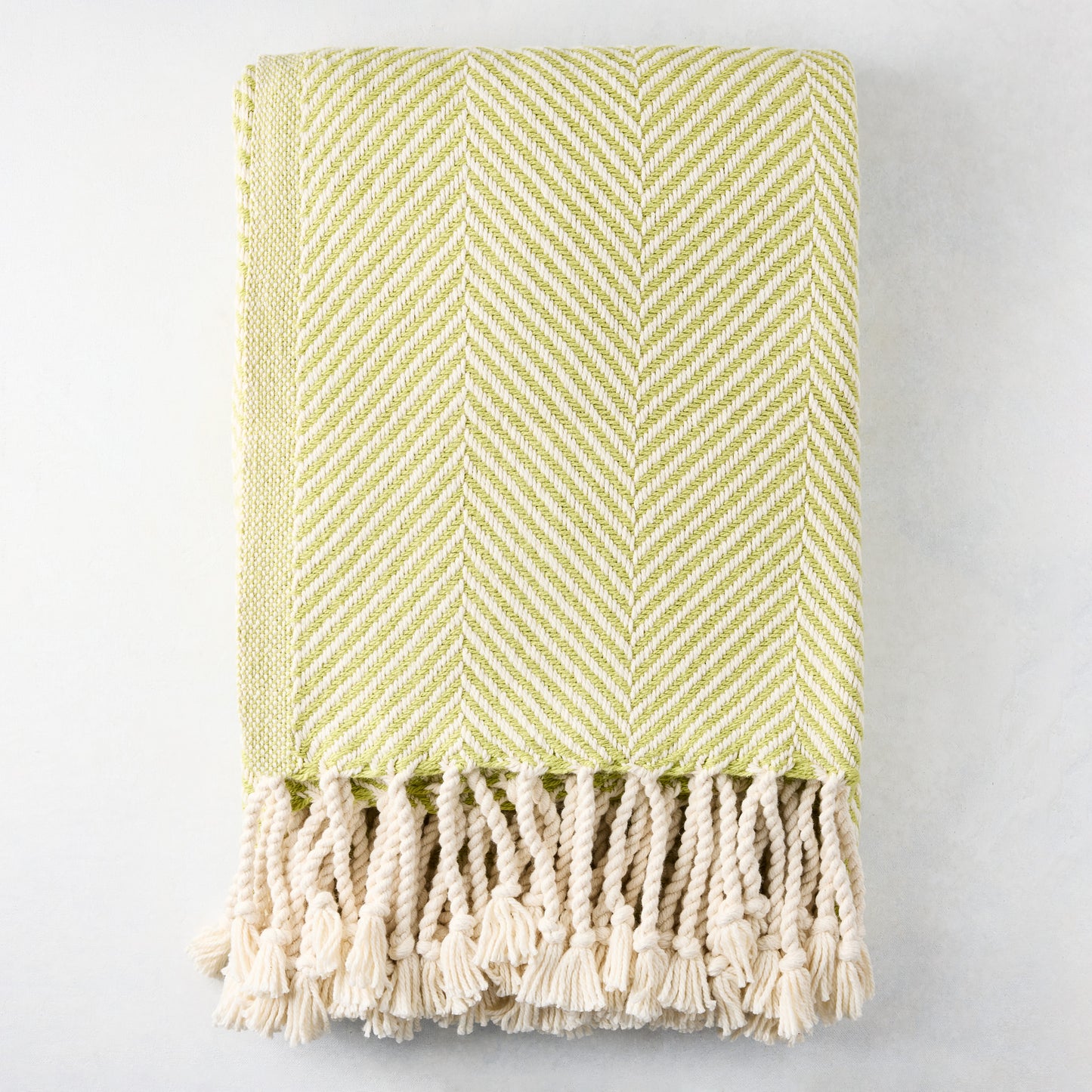 Green chevron cotton throw blanket with thick rope fringe.