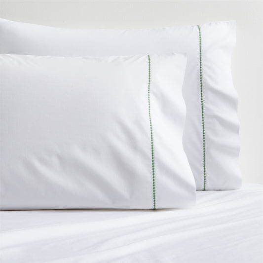 Set of 2 white percale pillowcases with a green diamond embroidered border.
