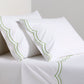 White organic cotton percale sheet set with green double scallop stitch embroidery on pillows and top sheet.