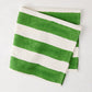Folded Green Hampton Cotton Stripe Napkin, 22" square, with bold green and white stripes.