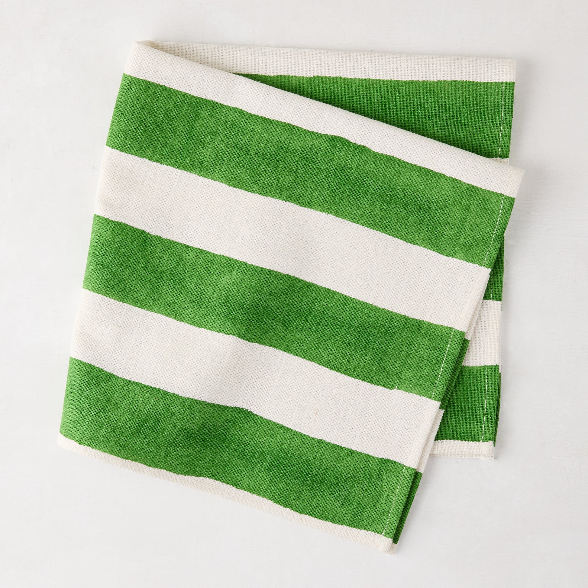 Folded Green Hampton Cotton Stripe Napkin, 22" square, with bold green and white stripes.