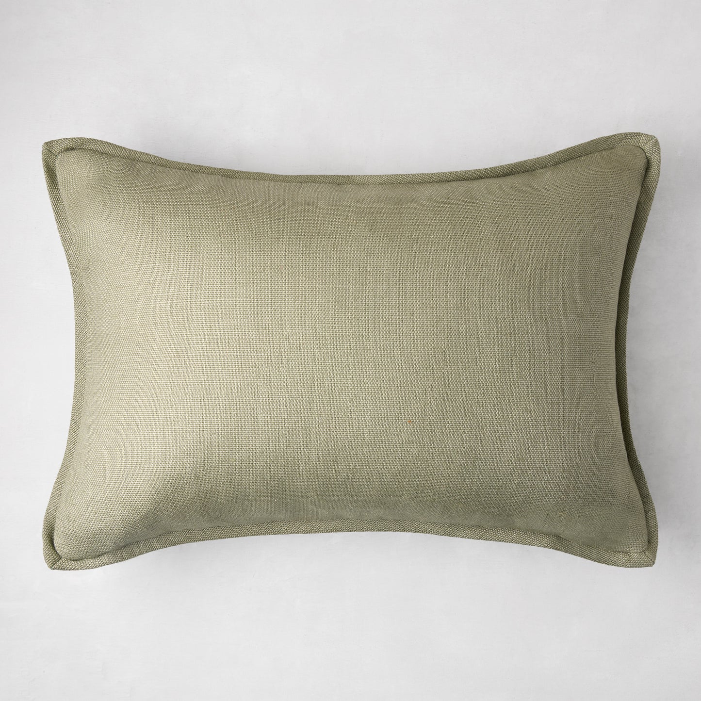 Celadon green linen lumbar pillow, 20"L x 14"H, with subtle texture and piped edges.