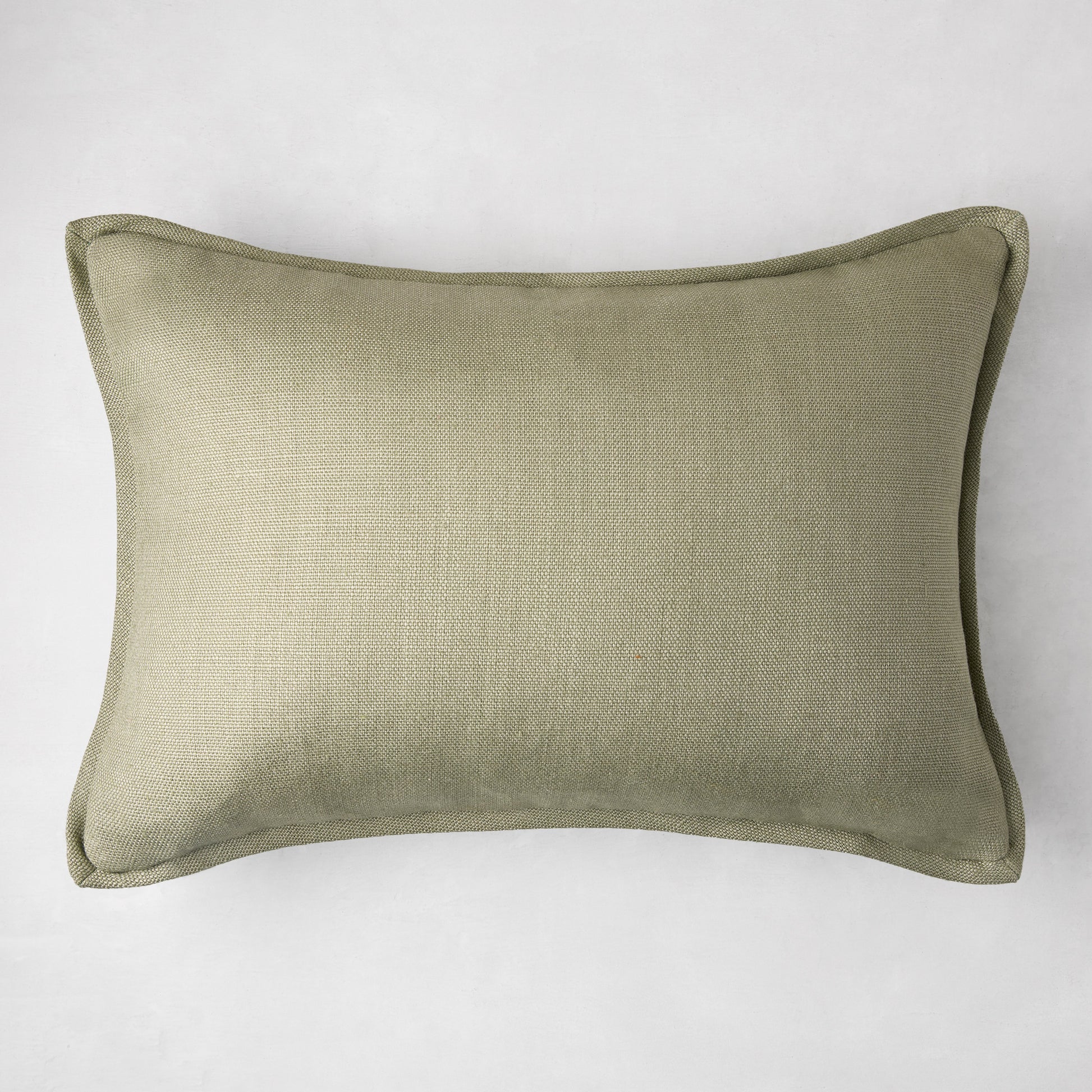 Celadon green linen lumbar pillow, 20"L x 14"H, with subtle texture and piped edges.