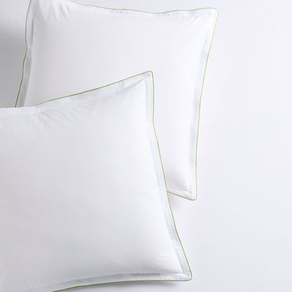 Set of two white percale Euro shams with delicate green piping and double-stitch detailing.