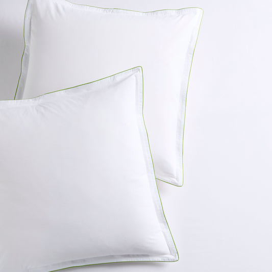 Set of two white percale Euro shams with delicate green piping and double-stitch detailing.