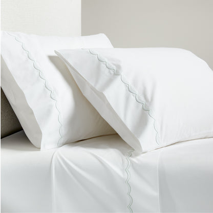 White percale sheet set with green scallop stitch edging on pillowcases and flat sheet.
