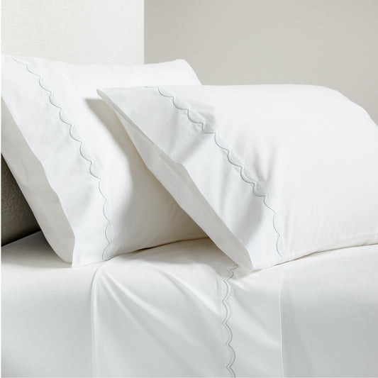 White percale sheet set with green scallop stitch edging on pillowcases and flat sheet.