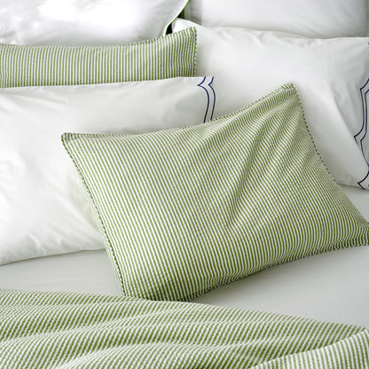 Green seersucker stripe organic cotton duvet and sham set on a white bed.