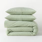 Stacked green seersucker stripe organic cotton duvet and two shams.