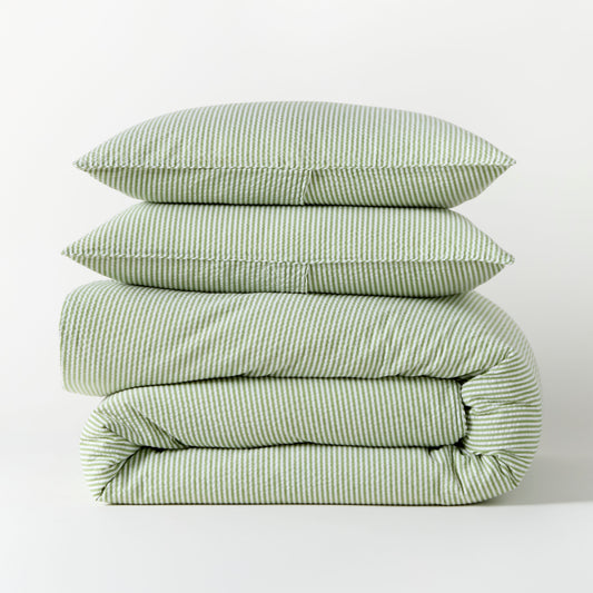 Stacked green seersucker stripe organic cotton duvet and two shams.