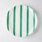 White round parchment liner with green vertical stripes and ruffled edges.