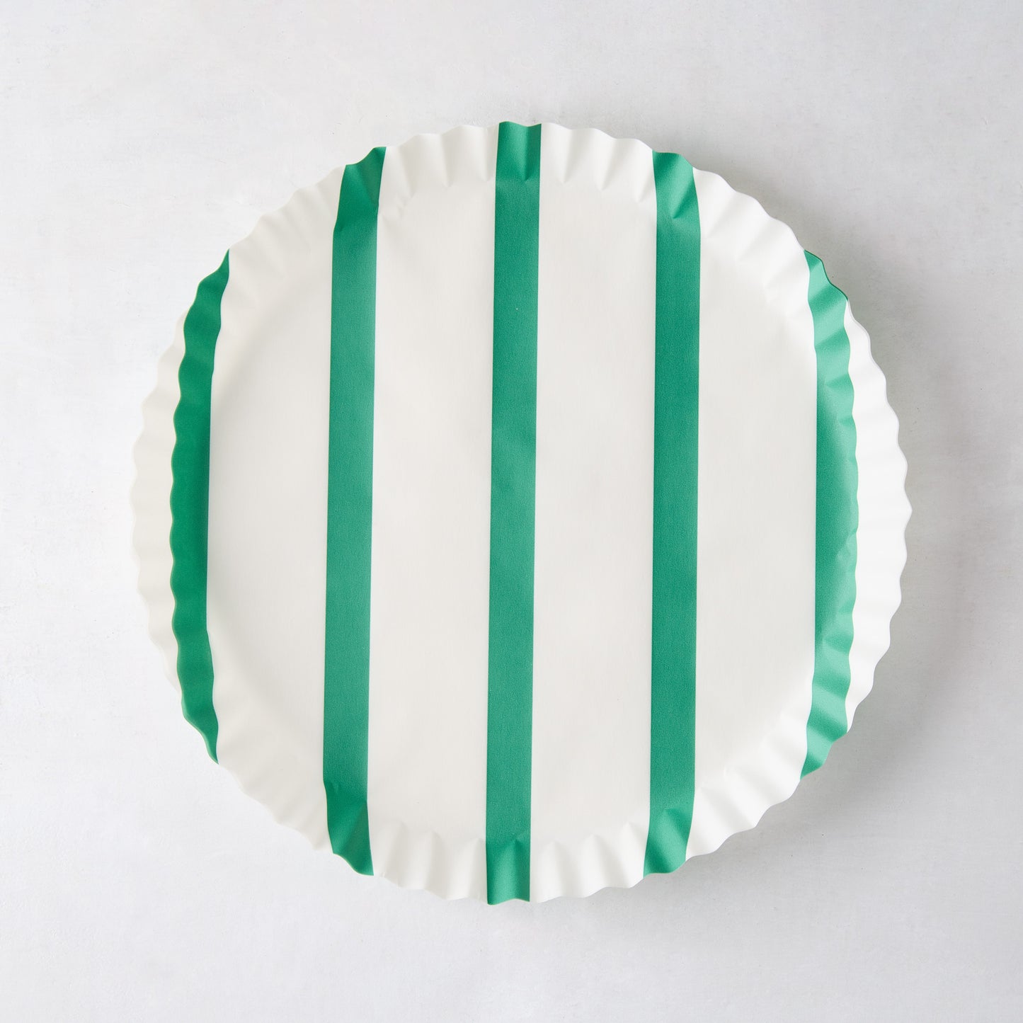 White round parchment liner with green vertical stripes and ruffled edges.