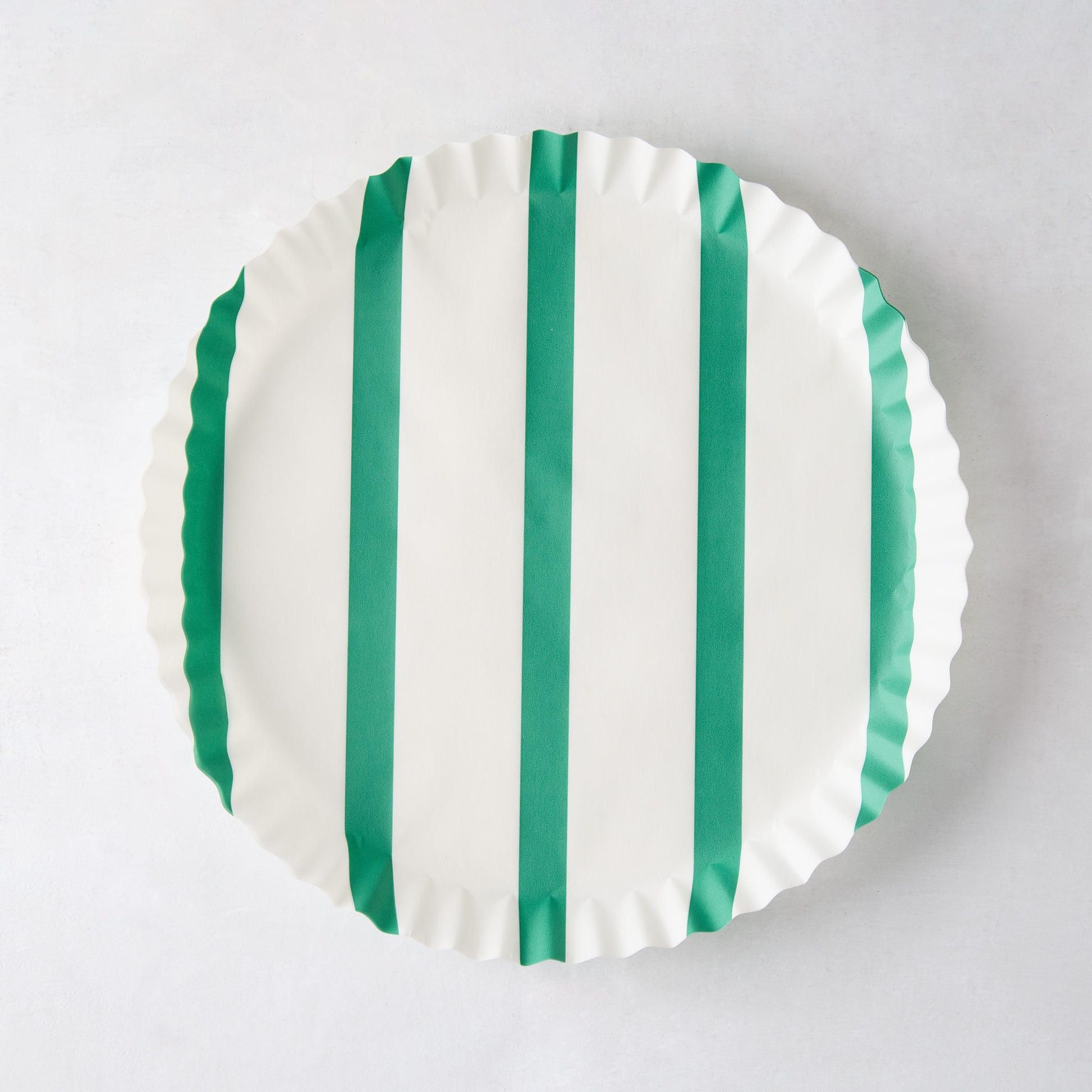 White round parchment liner with green vertical stripes and ruffled edges.