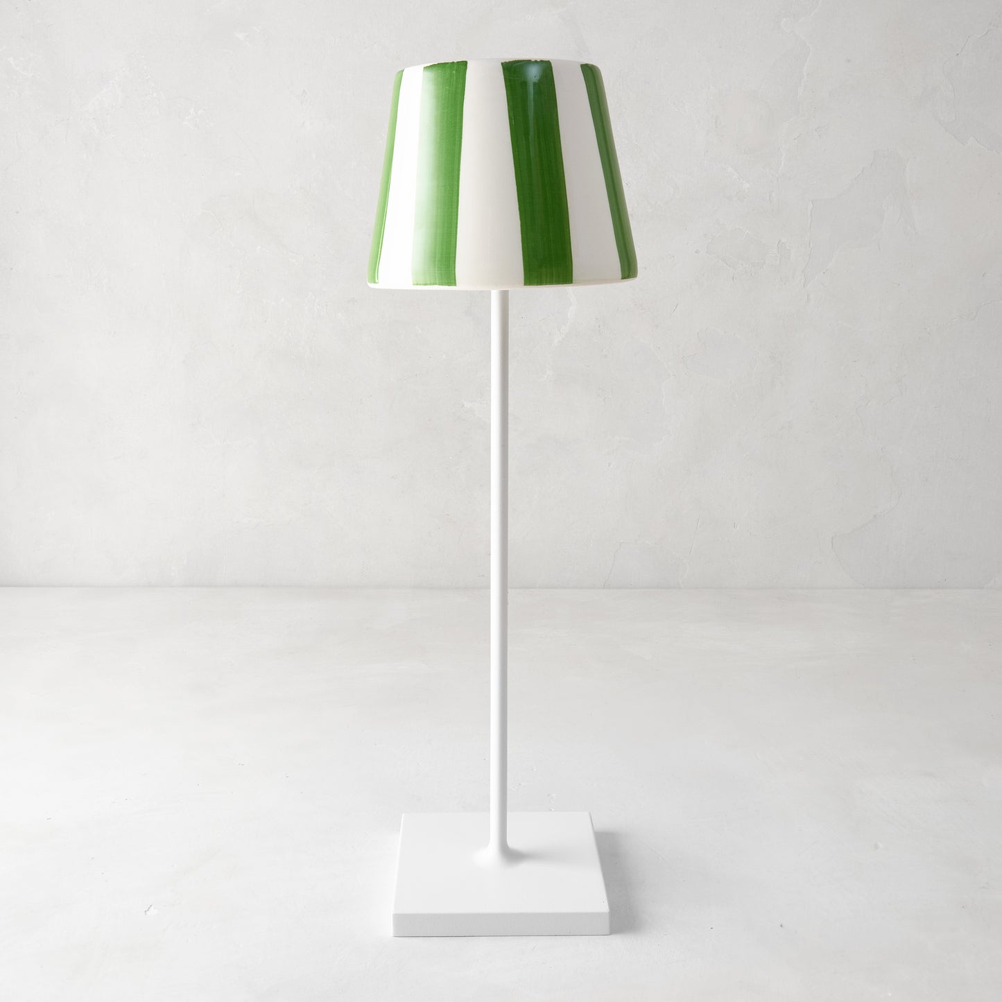 Green and white striped ceramic lamp shade on a white Poldina Pro lamp.