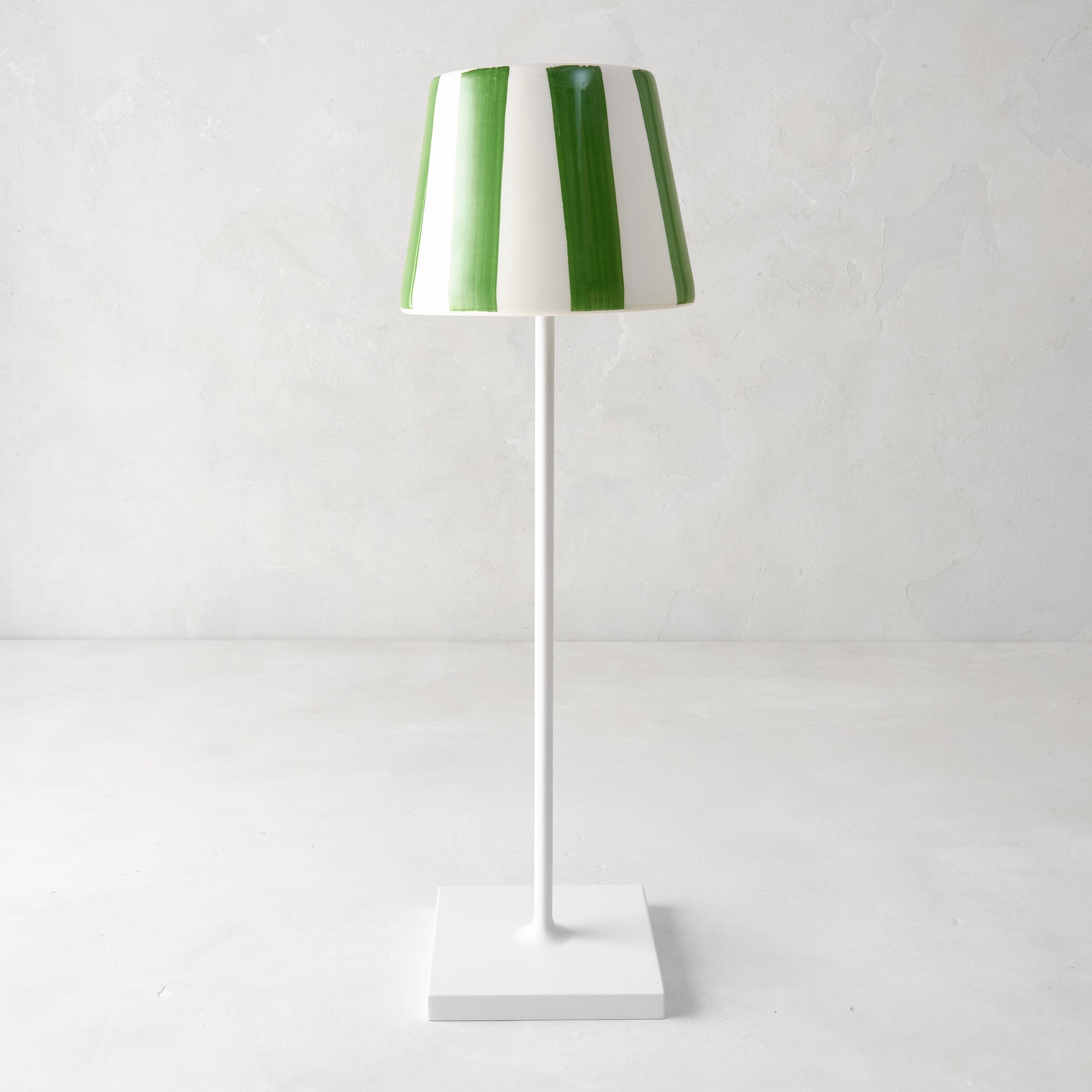 Green and white striped ceramic lamp shade on a white Poldina Pro lamp.