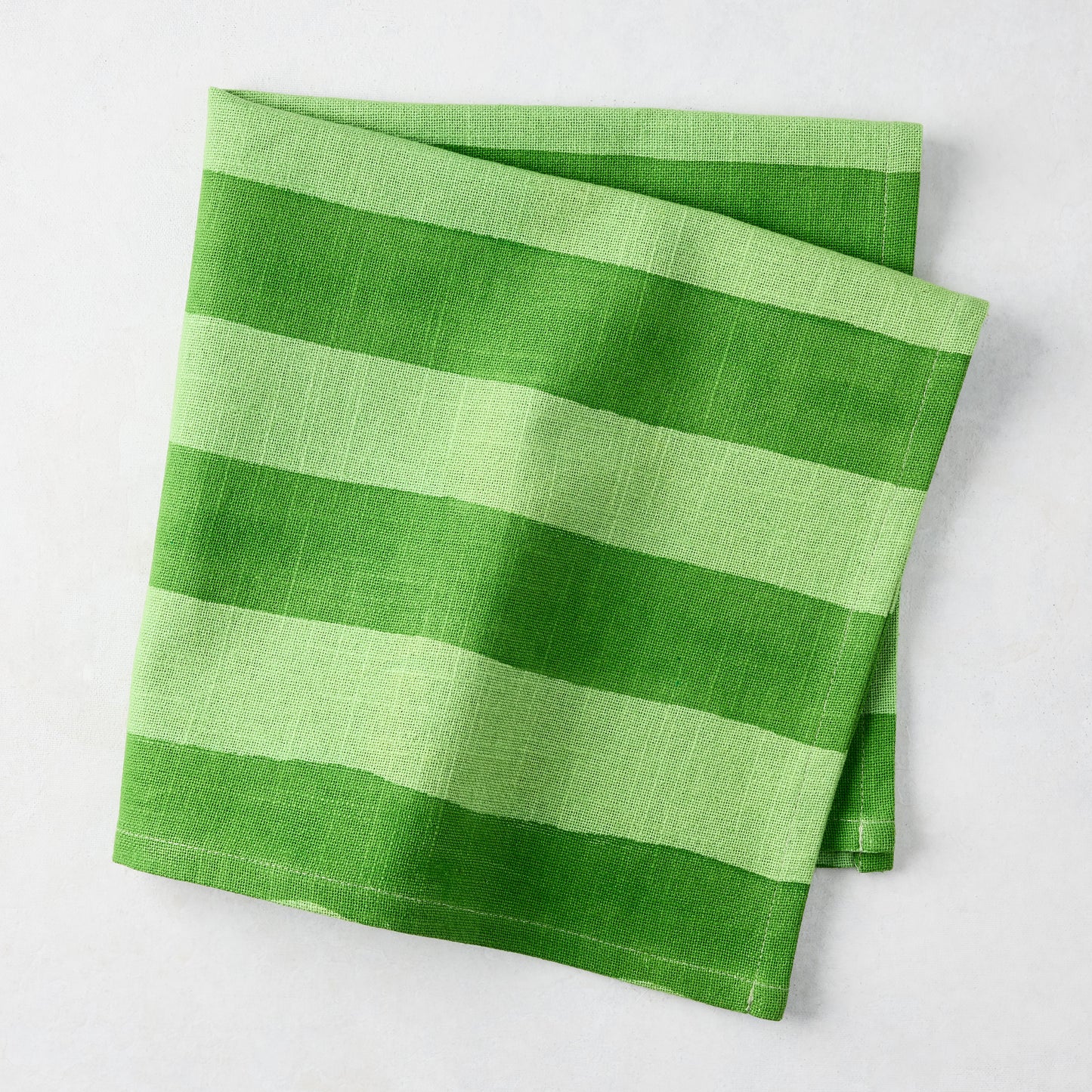 Folded Green Tonal Hampton Stripe Cotton Napkin, 22" square.