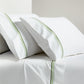 White percale sheet set with green triple-stitch trim on pillowcases and flat sheet.