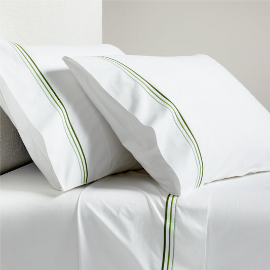 White percale sheet set with green triple-stitch trim on pillowcases and flat sheet.