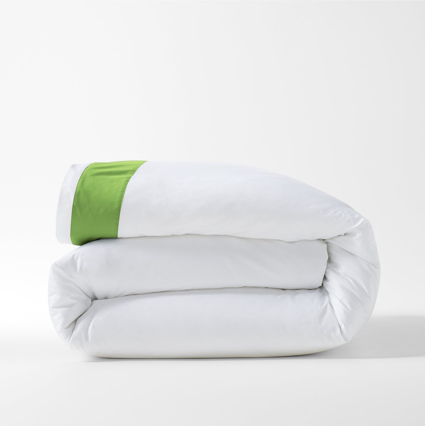 Folded white percale duvet cover with a bold green wide-band detail.