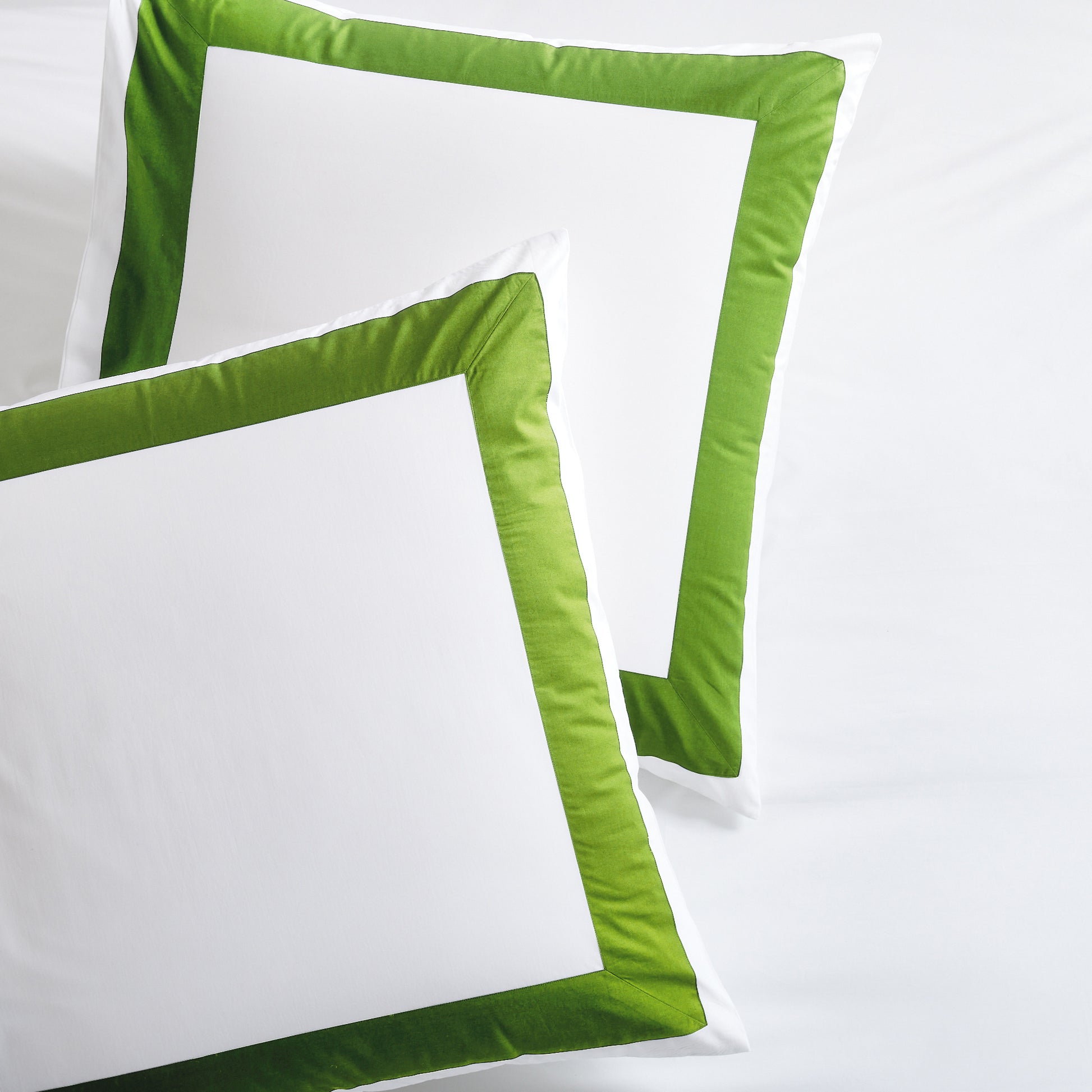 Two white percale pillow shams with a bold green wide-band border.