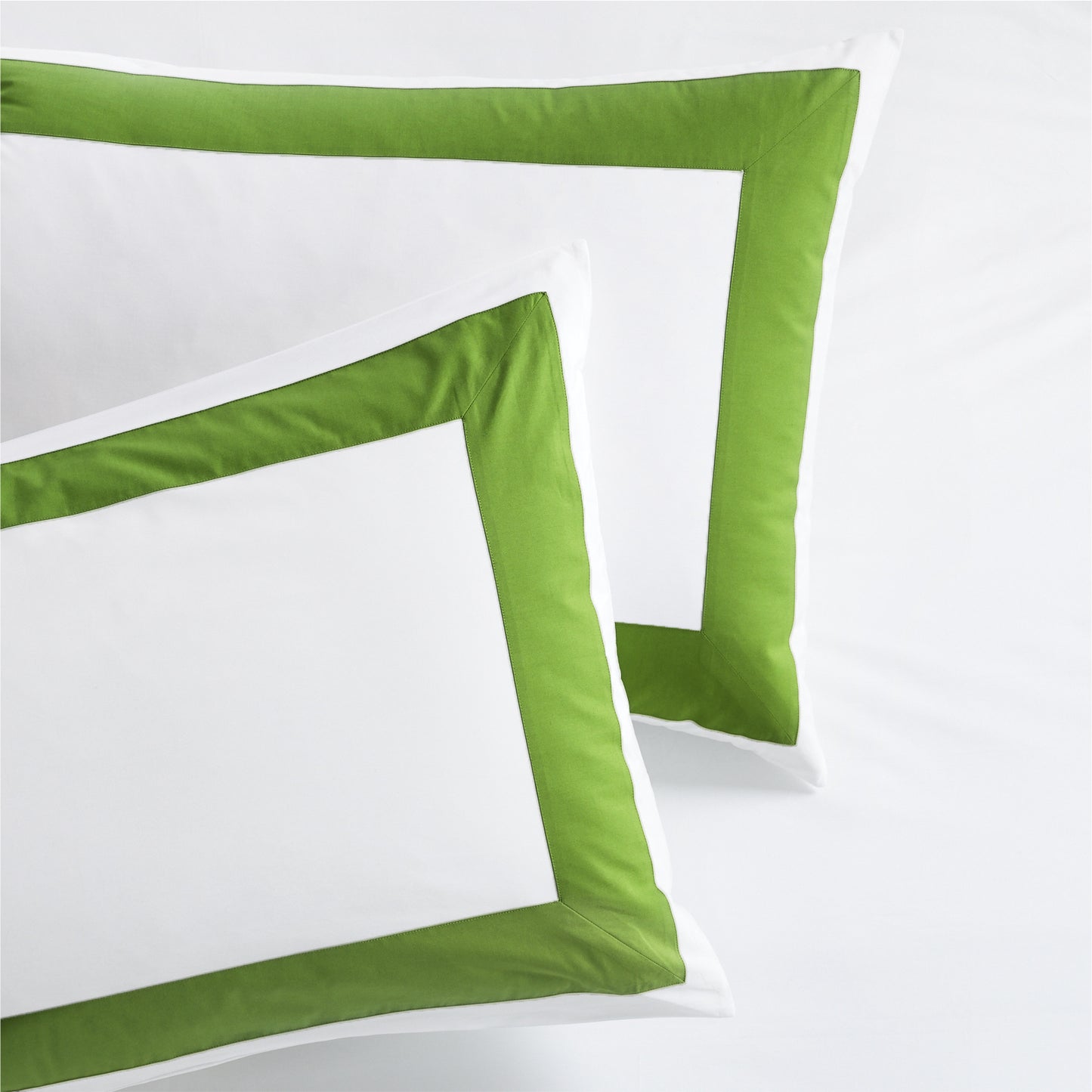 Set of 2 white percale pillow shams with a 4-inch wide green appliqued band.