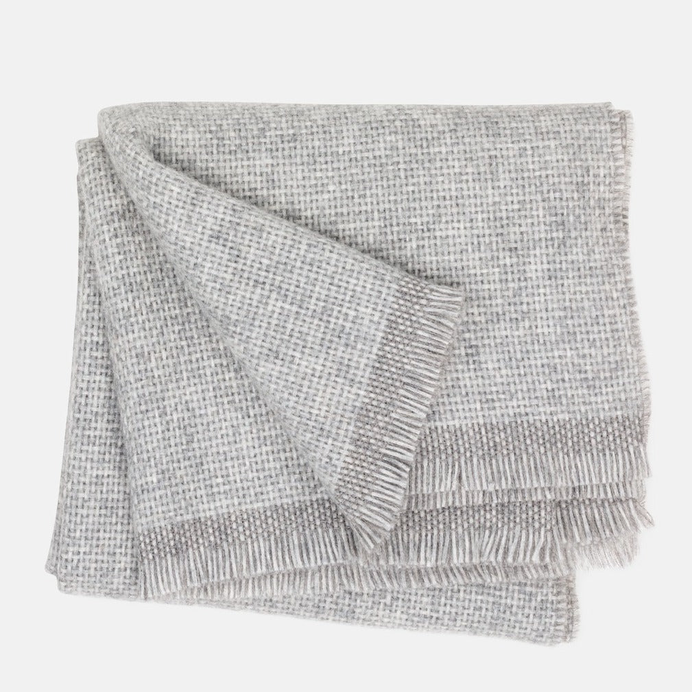 Folded Grey Azolla Alpaca Wool Throw Blanket with fringed edges and a subtle woven texture.