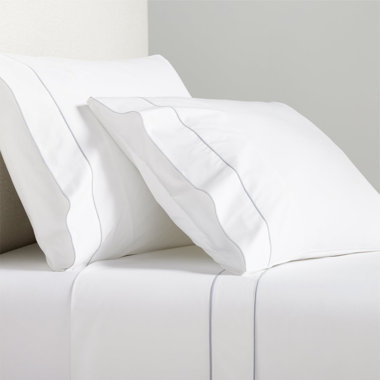 White percale sheet set with grey satin stitch border on pillows and flat sheet.
