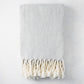 Grey chevron cotton throw blanket with thick rope fringe.