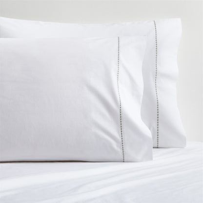 White percale pillowcases with grey diamond embroidered detail.