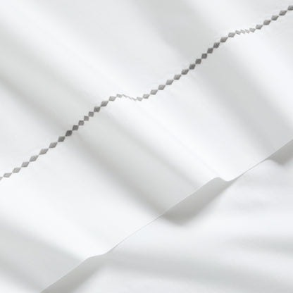 White percale sheet set with a grey diamond embroidered border.
