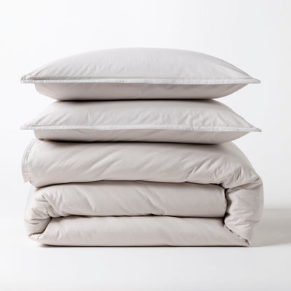 Stacked grey Italian percale duvet cover and two shams, made from long-staple cotton.