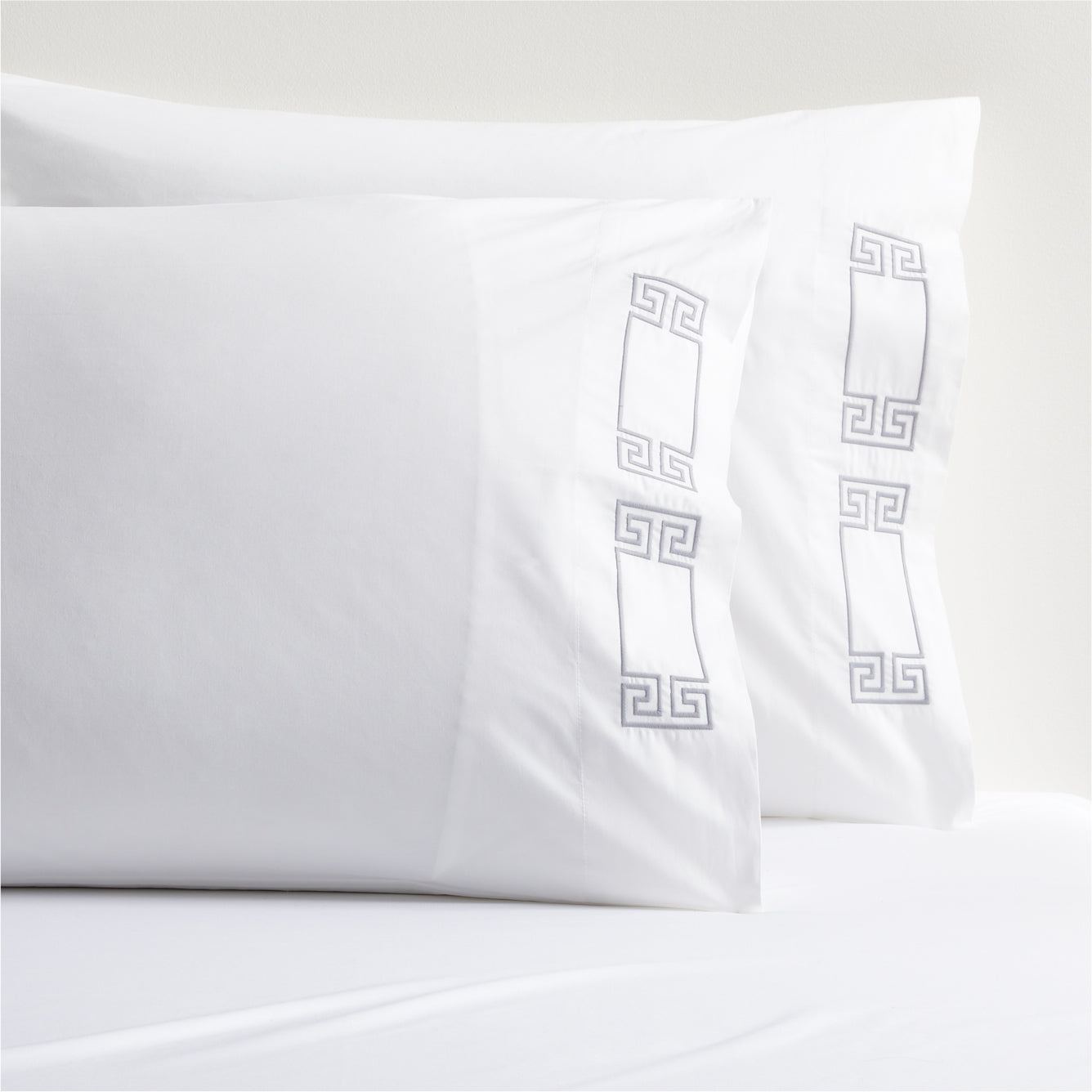 White percale pillowcases with grey embroidered Greek key border.