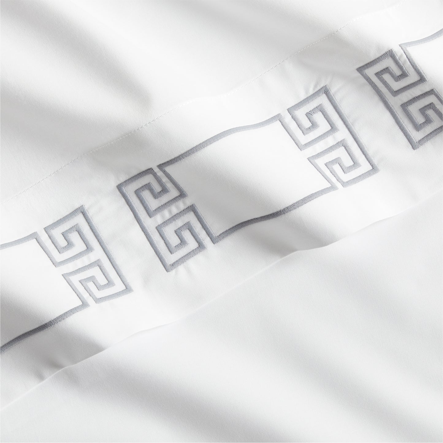 White percale sheet with a grey embroidered Greek key motif band.