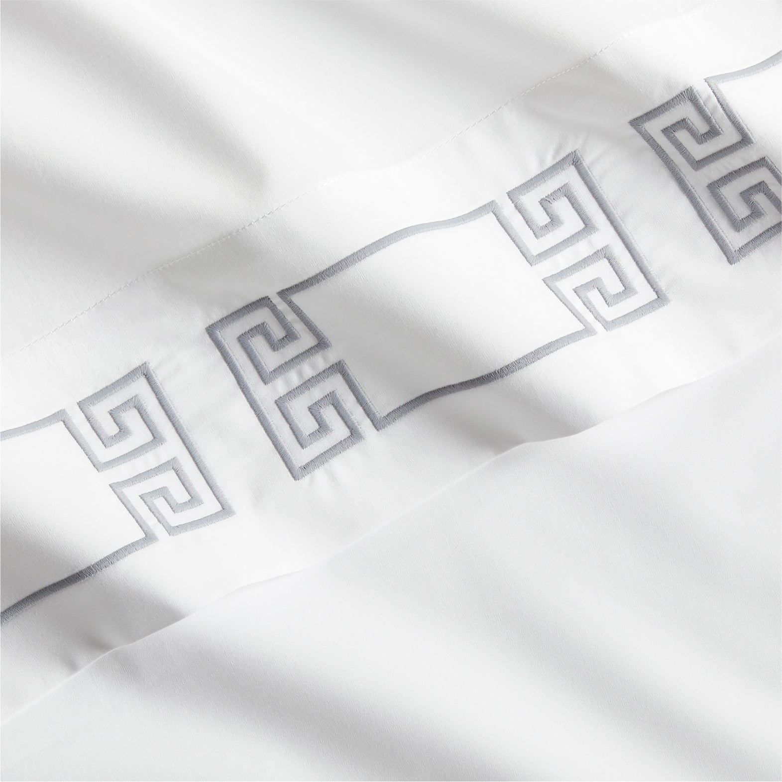 White percale sheet with a grey embroidered Greek key motif band.