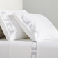 White percale sheet set with grey embroidered Greek key border on pillowcases and flat sheet.