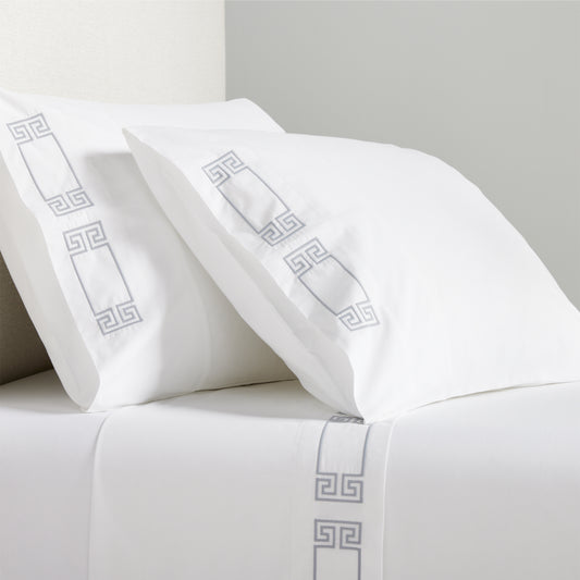 White percale sheet set with grey embroidered Greek key border on pillowcases and flat sheet.