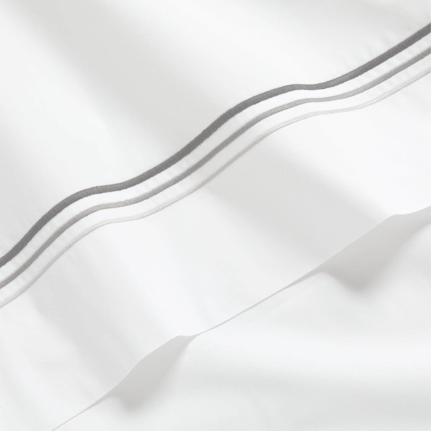 White percale sheet with three ombre grey embroidered triple stitches.