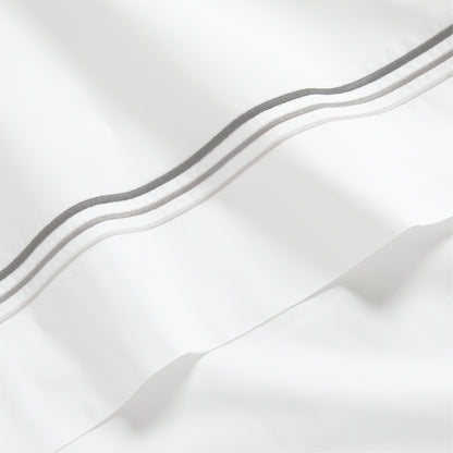 White percale sheet with three ombre grey embroidered triple stitches.