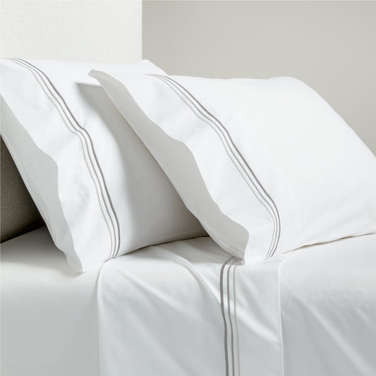 White percale sheet set with grey triple stitch embroidery on pillowcases and flat sheet.