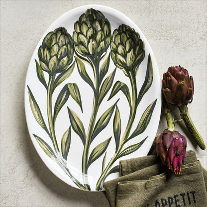 Oval ceramic serving platter with hand-painted green artichoke design on a white glazed background, 15.75 inches long.