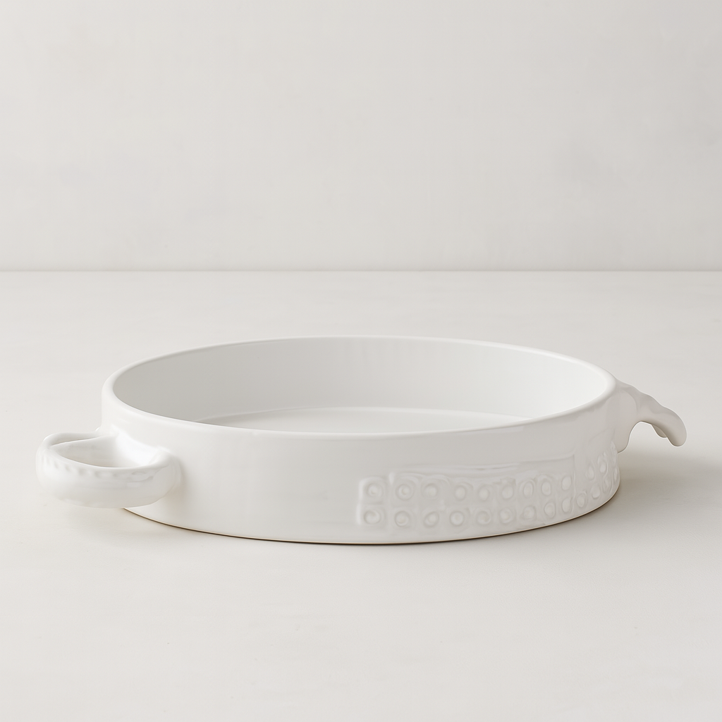 Handmade creamy white ceramic baker by Montes Doggett, 11"Dia, with organic shape and textured side detail.