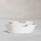 Set of 2 handmade white ceramic Montes Doggett bowls with organic shapes, one nested inside the other.
