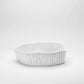 White, handmade Montes Doggett ceramic bowl with organic shape and textured vertical ridges.