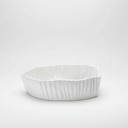 White, handmade Montes Doggett ceramic bowl with organic shape and textured vertical ridges.