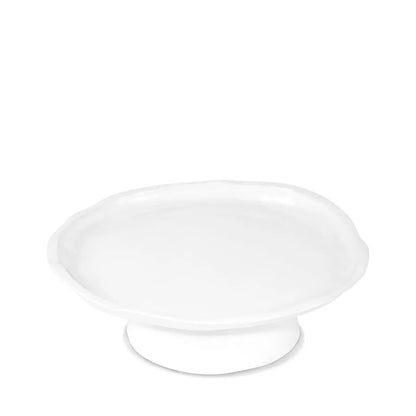 Small handmade creamy white ceramic cake stand with organic wavy edges.