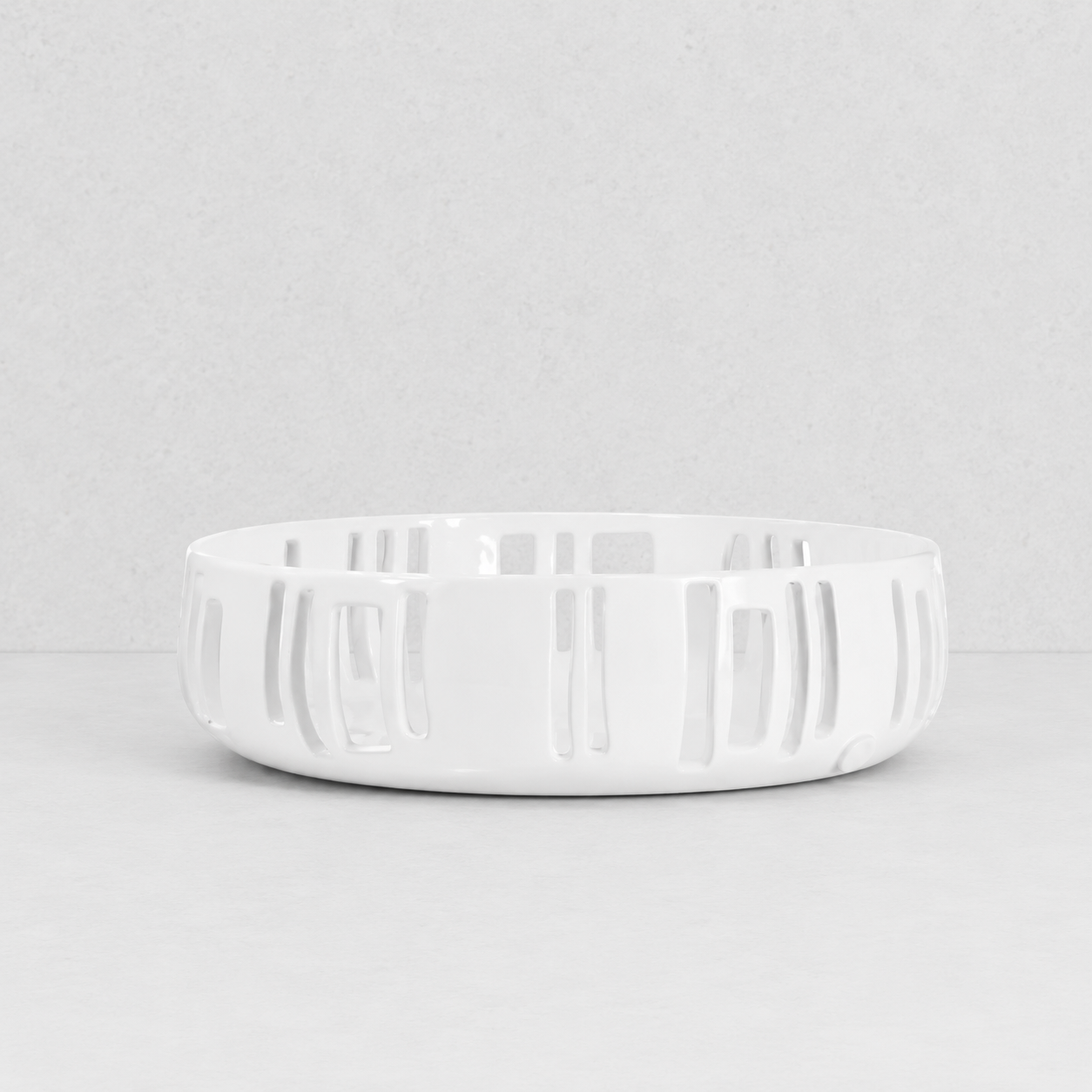 Handmade creamy white ceramic colander by Montes Doggett, 12"Dia x 3.5"H, with vertical slotted design.