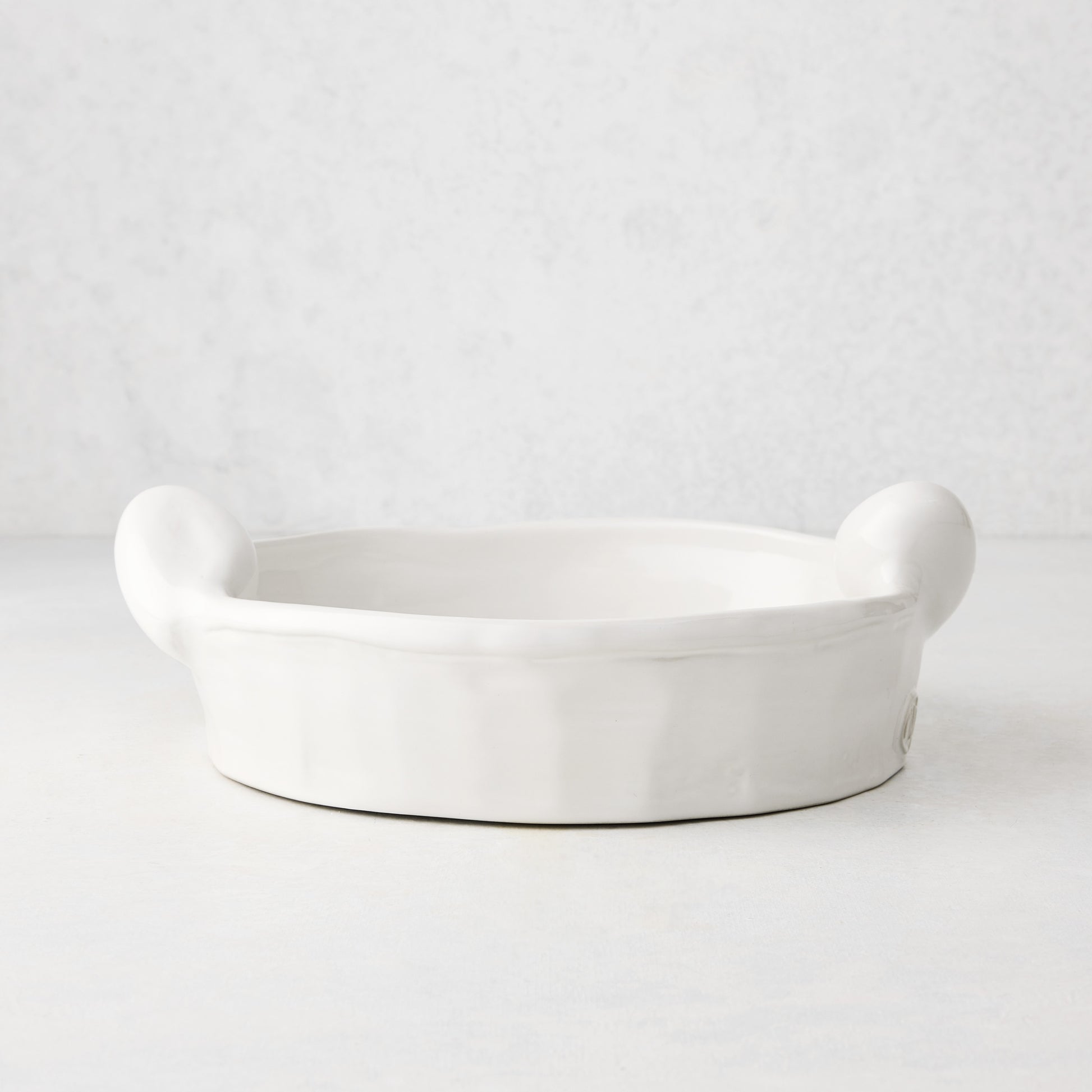 Handmade Montes Doggett ceramic round baker, creamy white glaze, 9"Dia x 2.5"H, with small handles.