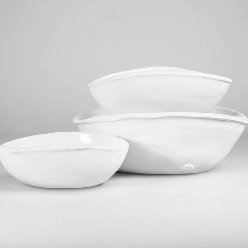 Set of 3 handmade Montes Doggett oval ceramic bowls in creamy white glaze, varying sizes.