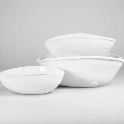 Set of 3 handmade Montes Doggett oval ceramic bowls in creamy white glaze, varying sizes.